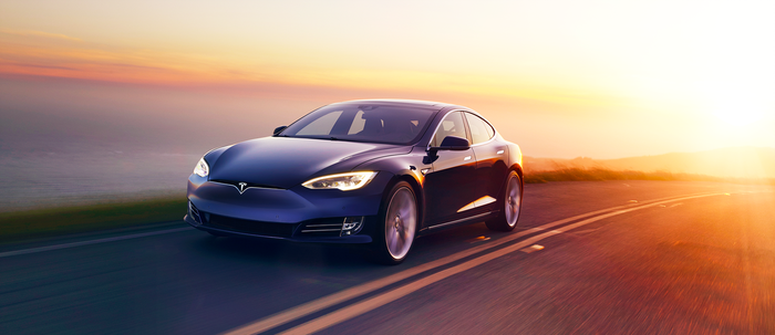 Blue Tesla Model S su una strada al crepuscolo.
